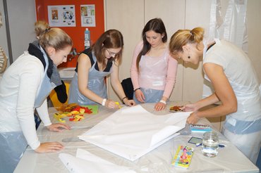 4 Auszubildende bauen einen Papierdrachen