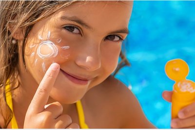 Sonnenbrillen und Sonnencreme schützen Kinder beim Aufenthalt im Freien vor Sonnenbrand und Augenschäden