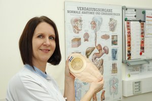 Pflegerin mit Stomabeutel in der Hand